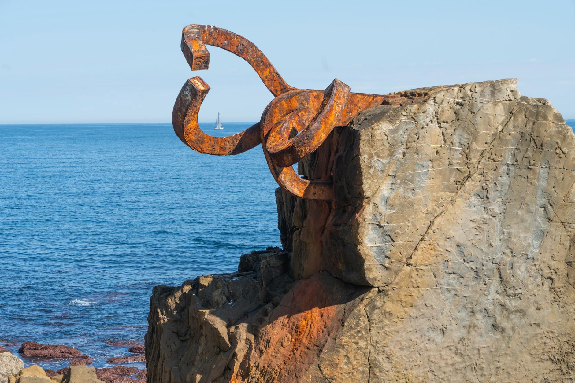 rusty sculpture on coastal rock in spain