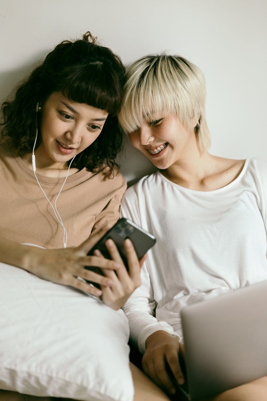 women looking at smartphone together and smiling