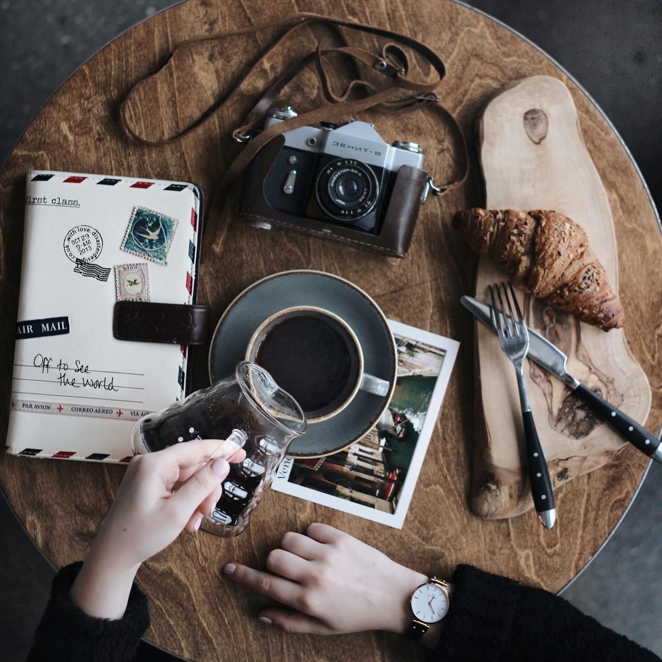 baked bread on brown wooden surface beside grey point and shoot camera on table