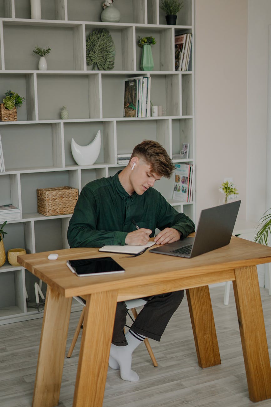 man in green long sleeve shirt sitting on writing